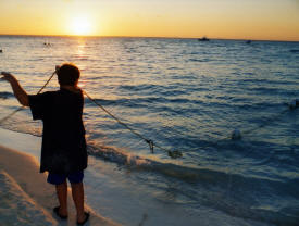 Adam Caddell pulling in the fish net Isla Mujeres Quintana Roo, Mexico Photography by Bill Bel